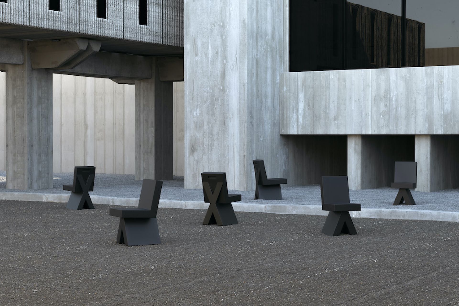 Mehrere moderne, schwarze Design-Stühle im Außenbereich vor einem Betongebäude. Minimalistische Sitzmöbel für Garten und Terrasse.