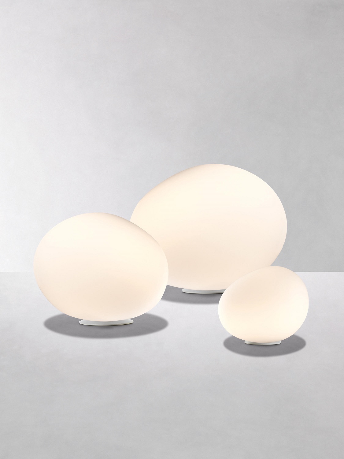 Drei weiße Poly Gregg Tischleuchten von Foscarini in verschiedenen Größen.