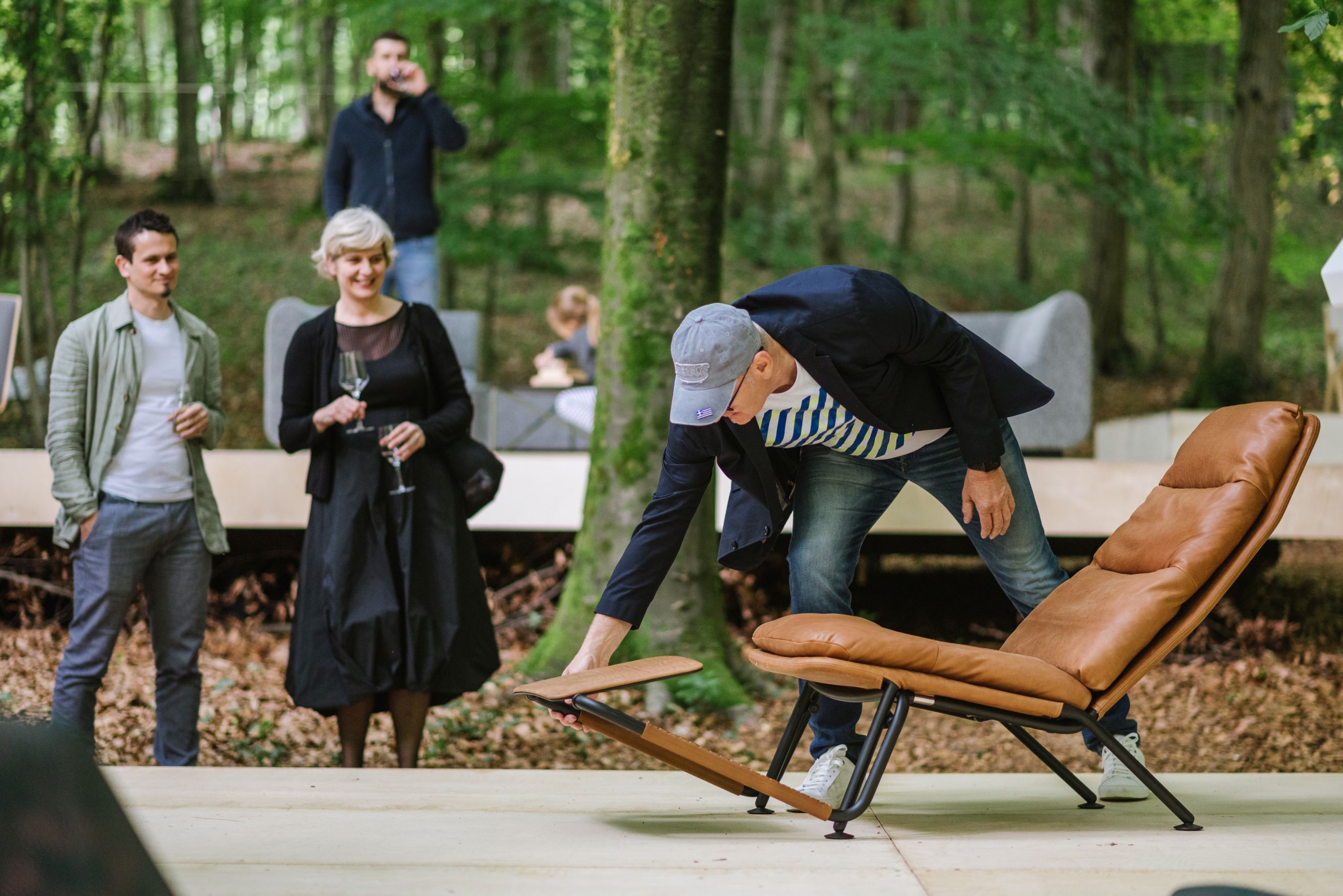 Kontrapunkt Liegesessel von Prostoria aus Leder, braun, im Freien mit Menschen. Designmöbel für Wohnen.