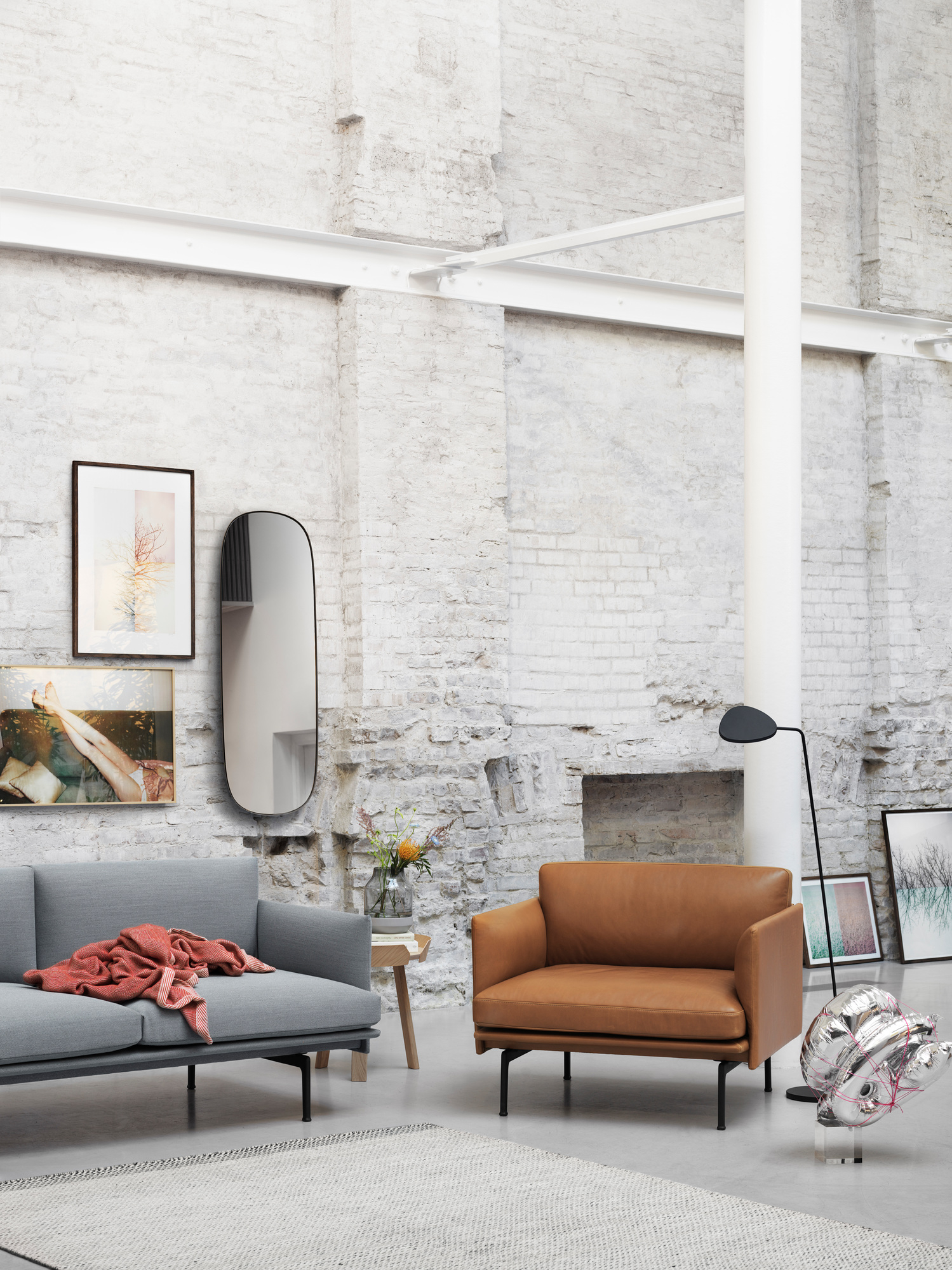 Wohnzimmer-Szene mit grauem Sofa, braunem Sessel und Muuto Around Coffee Table aus Eiche.