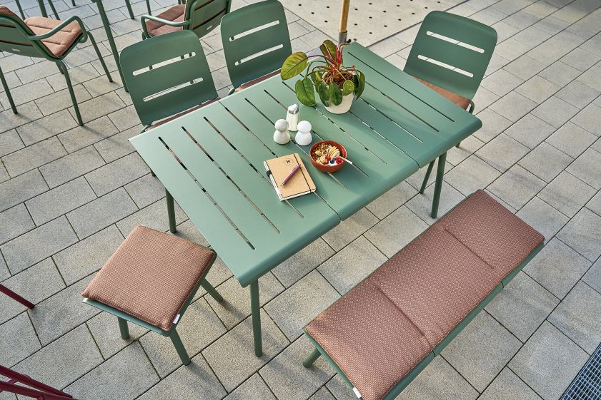 Weishäupl Vapio Outdoor Stuhl und Tisch-Set in Grün mit braunen Sitzkissen auf einer Terrasse.