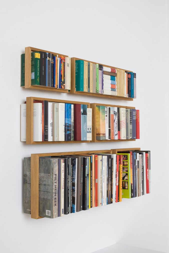 Drei kleine, schwebende Eiche Regale "Regal b" an einer weißen Wand, gefüllt mit Büchern.