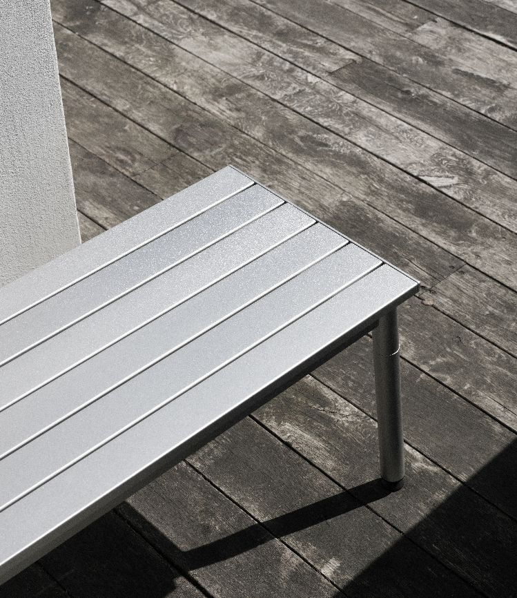 Detailaufnahme der silbernen Ex Bank Outdoor von Normann Copenhagen auf einer Holzterrasse.