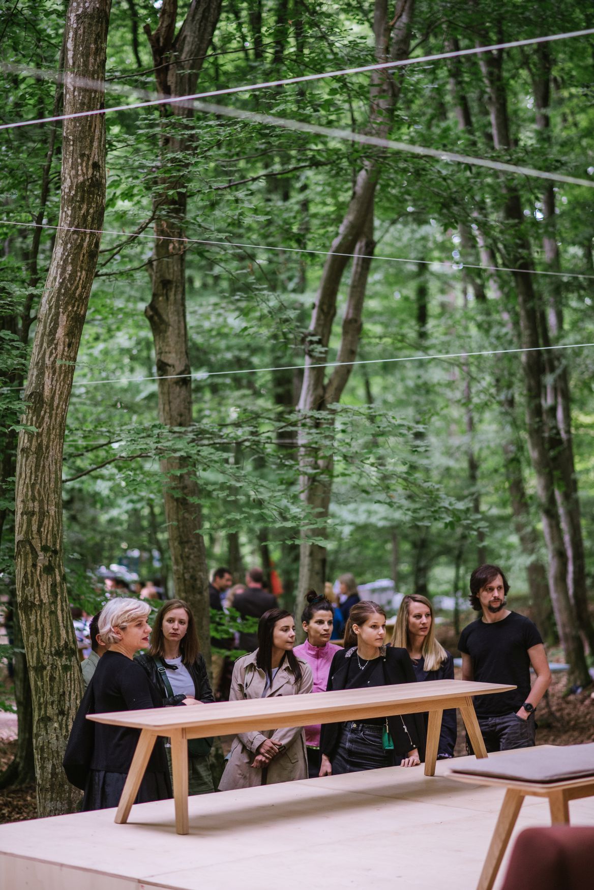 Monk Tisch von Prostoria im Wald, umgeben von Menschen. Moderner Holztisch für Esszimmer und Wohnbereich.