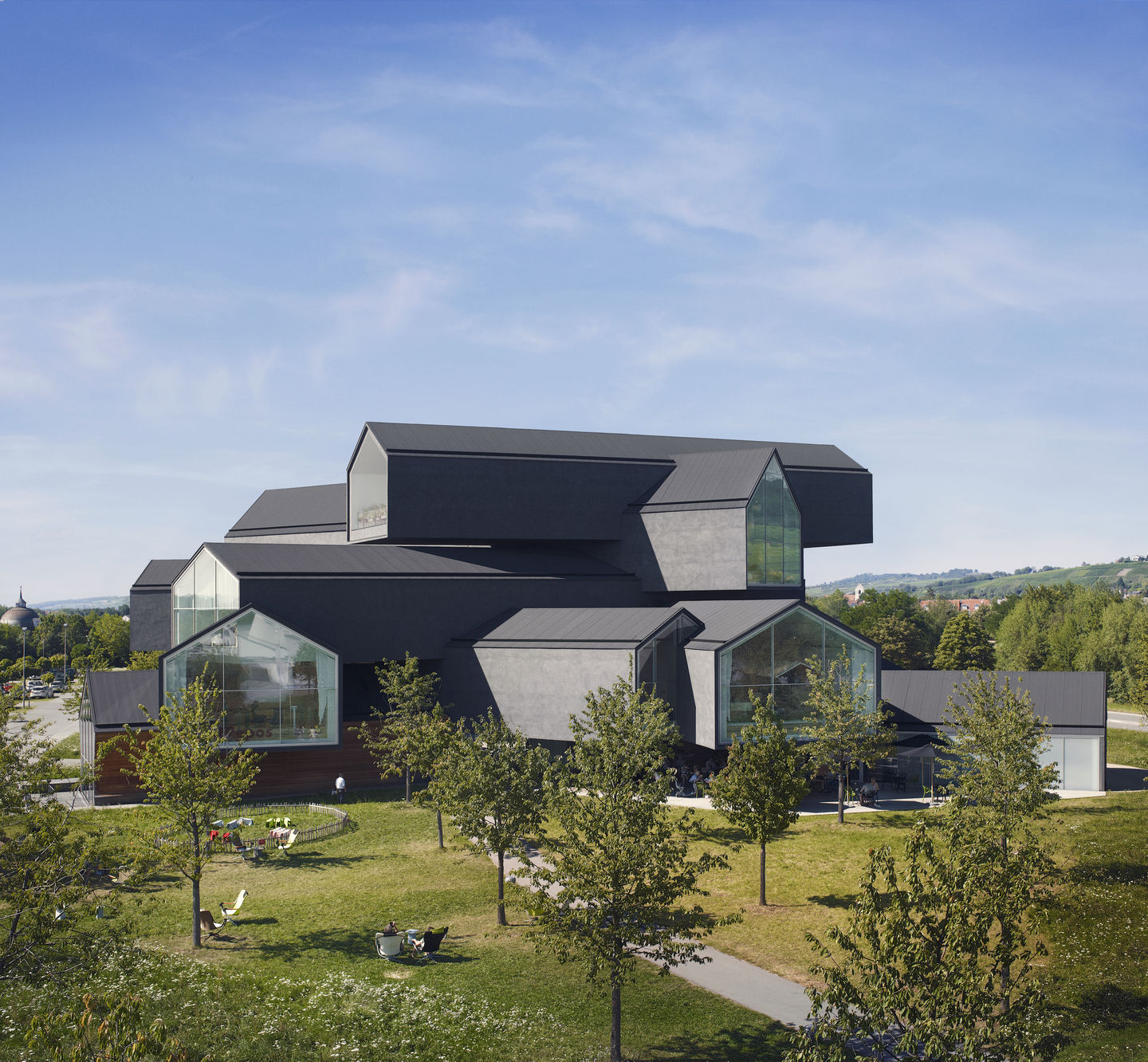 Außenansicht des Vitra Haus in Weil am Rhein, modernes Design mit grauen Giebeln und Glasfronten.