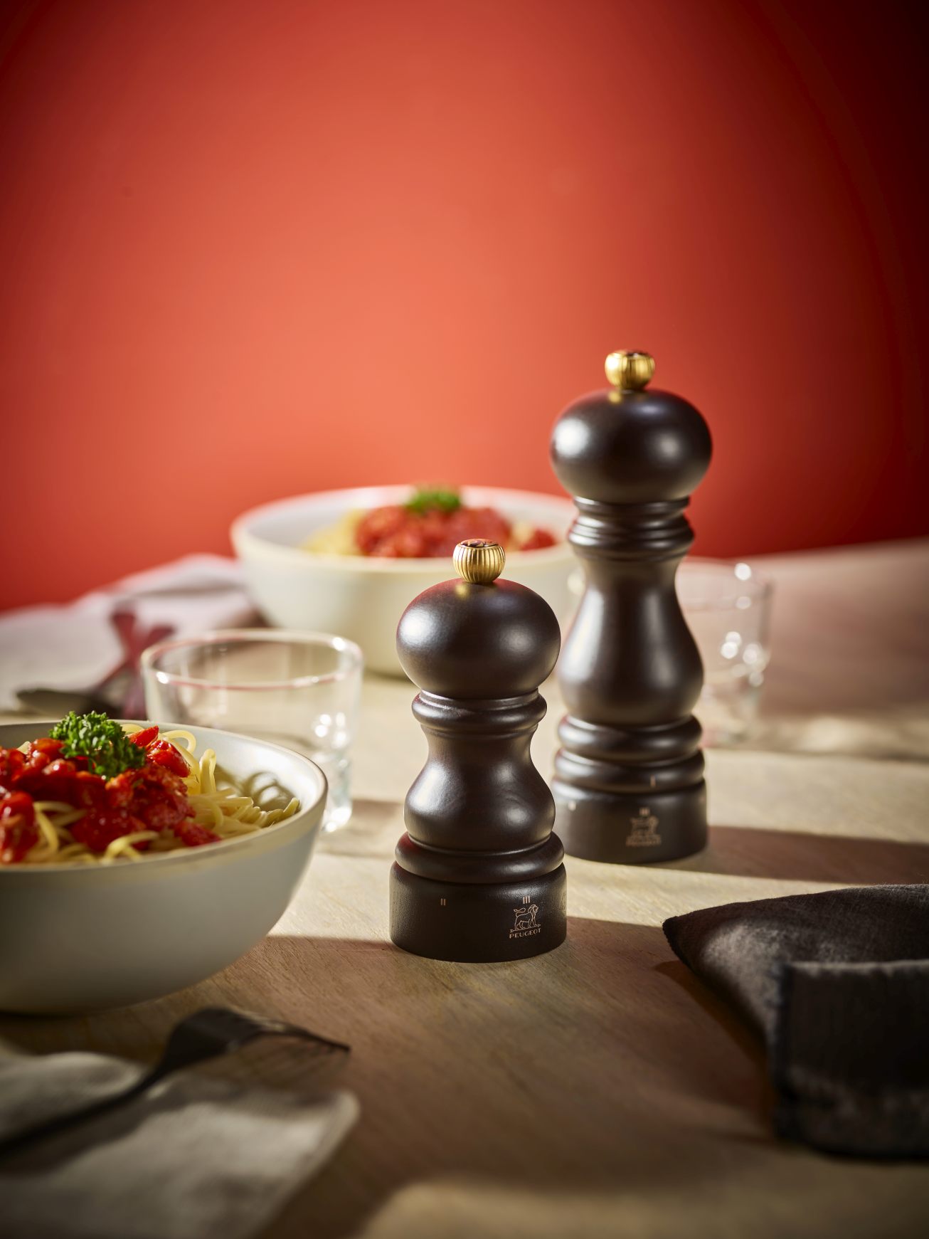 Produktfoto: Peugeot Paris Pfeffermühle in Schokolade, 18 cm, auf einem Tisch mit Pasta.
