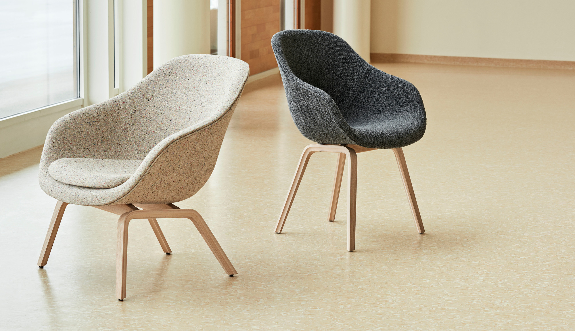 Zwei About a Lounge AAL 83 Sessel von Hay in Beige und Grau mit Holzgestell.