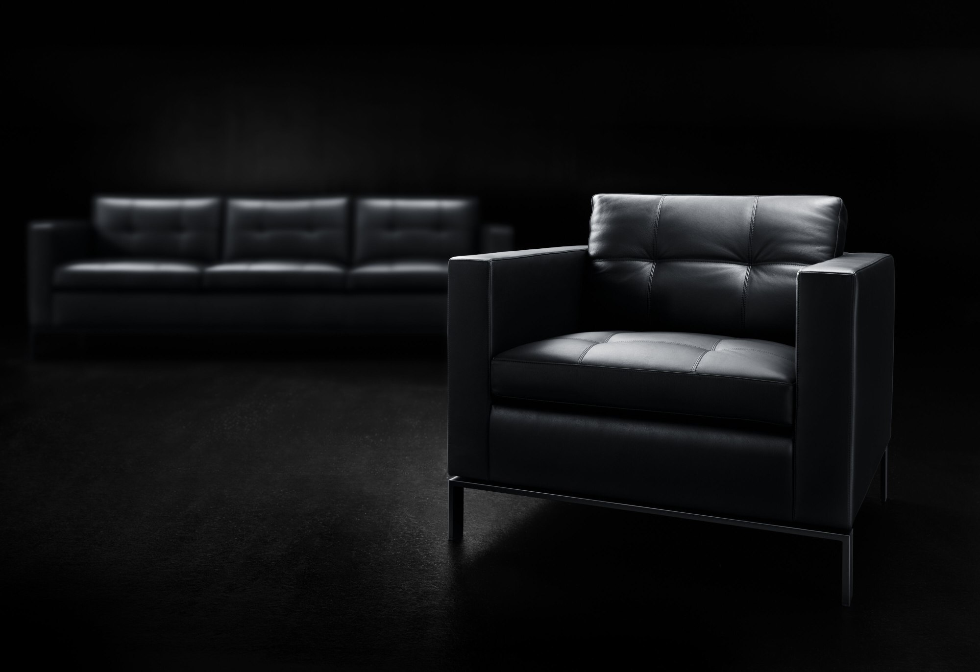Schwarzer 502 Foster Sessel von Walter Knoll mit Lederbezug und Metallbeinen vor dunklem Hintergrund.