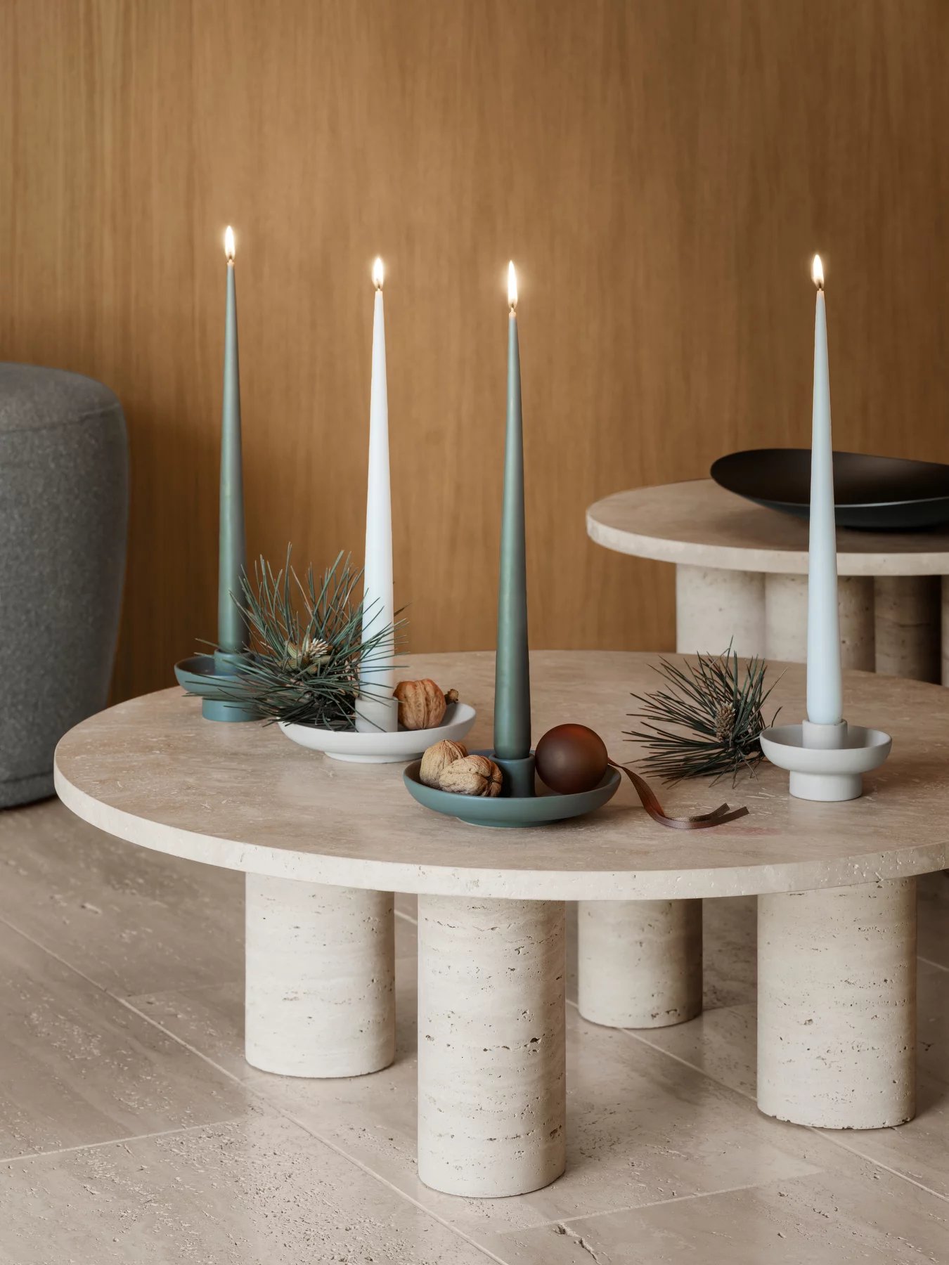 Nahaufnahme des runden Blomus Volos Couchtisches mit Travertin-Tischplatte und dekorativen Kerzenhaltern, ideal für moderne Wohnzimmer.