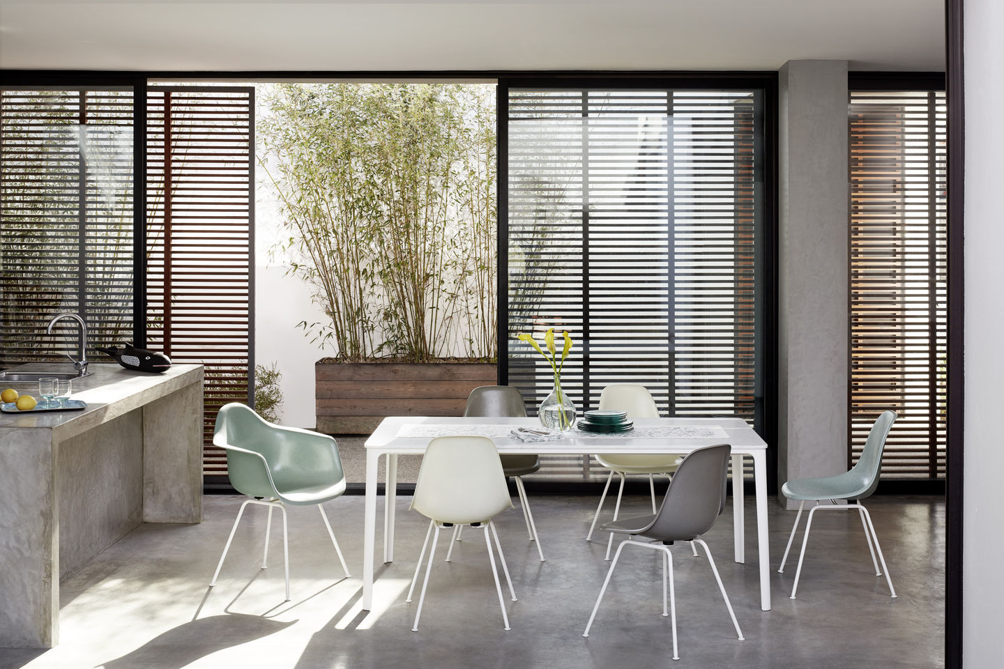 Esszimmer mit Esstisch und mehreren Vitra Eames Plastic Side Chairs DSX in verschiedenen Farben.