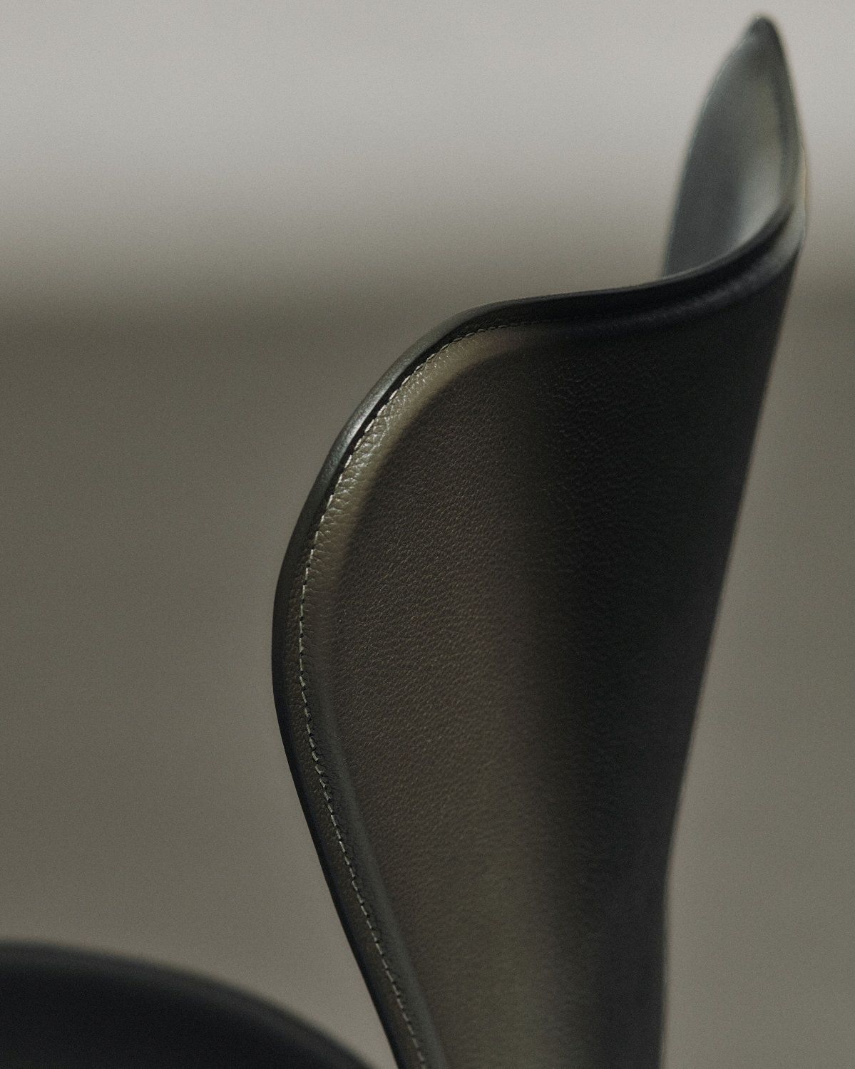 Detailaufnahme der Rückenlehne des Siebener Stuhls / Serie 3107 von Fritz Hansen mit Lederbezug.
