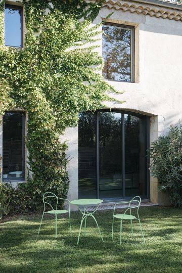 Airloop Bridge Sessel von Fermob im Garten: Zwei grüne Outdoor Sessel mit Tisch.