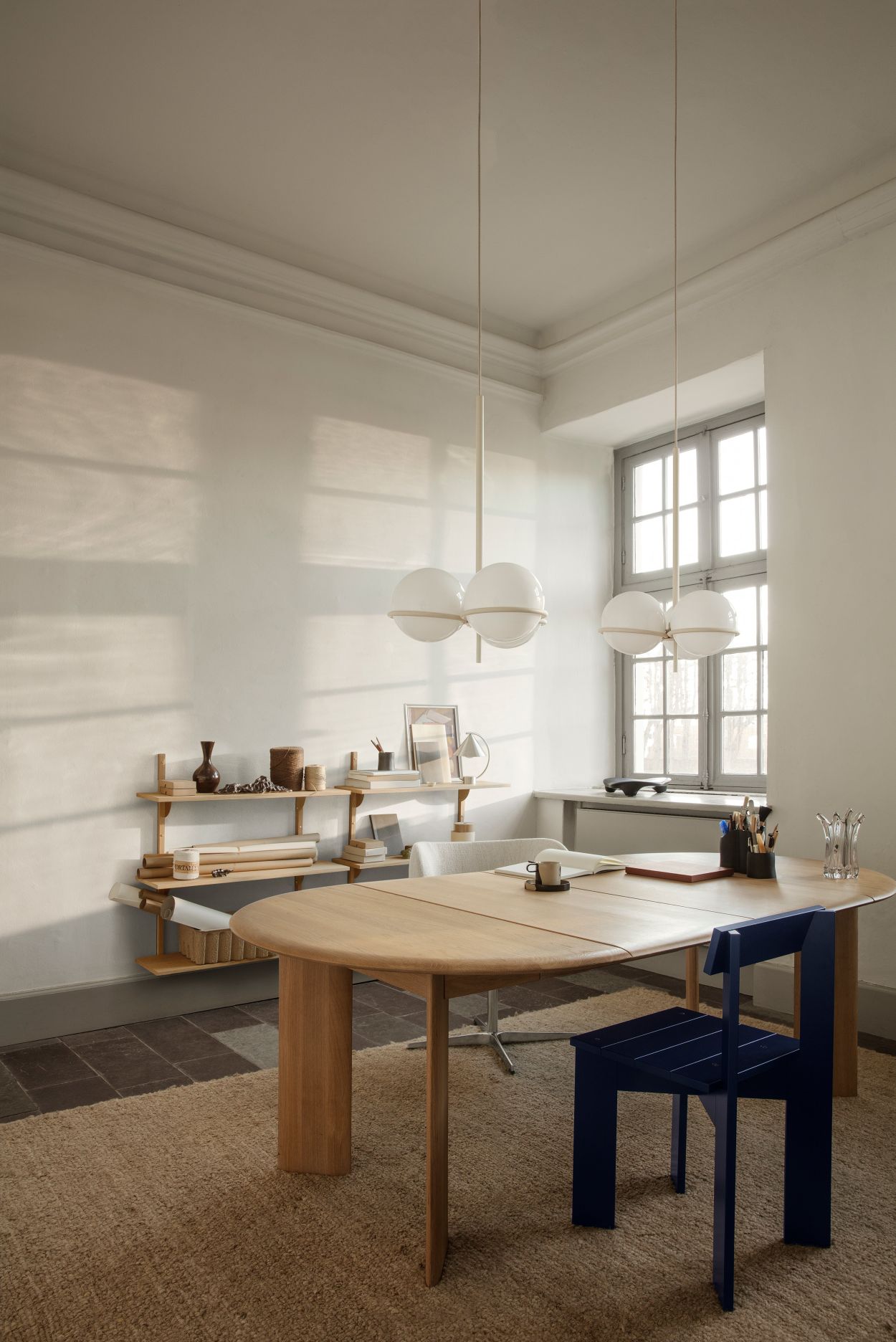 Blauer Ark Dining Chair Stuhl von Ferm Living am Esstisch in einem hellen Raum.