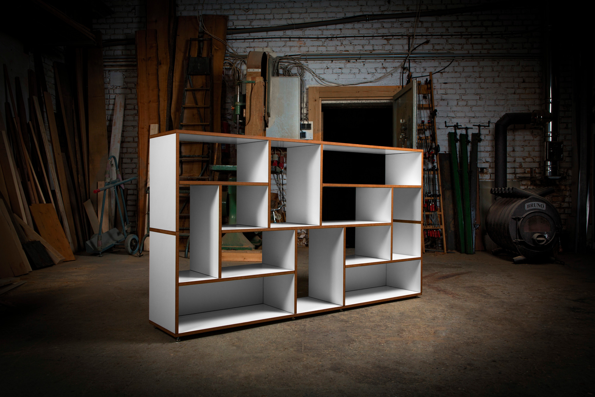 Hanibal Sideboard Tojo: Modernes, weißes Holzregal mit offenen Fächern im Werkstatt-Ambiente.