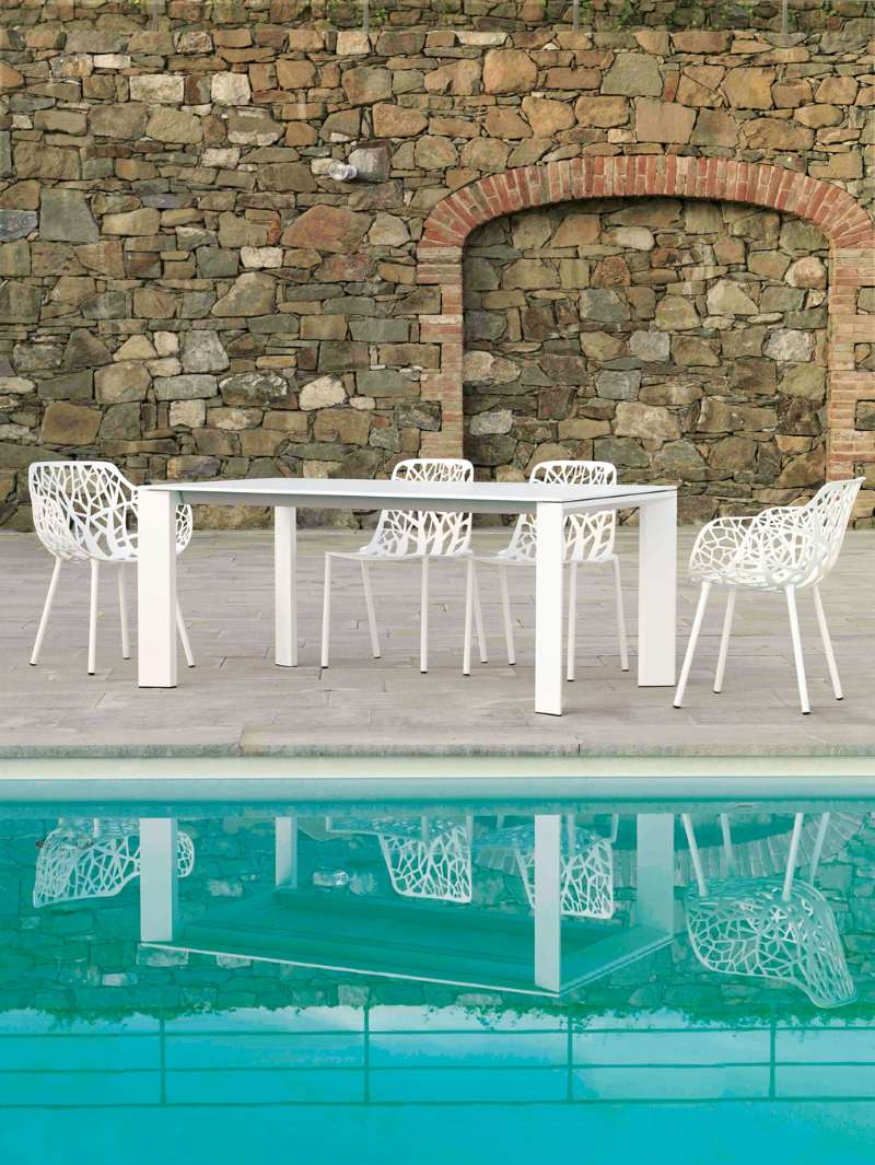 Grande Arche Outdoor Tisch von Fast mit weißen Stühlen am Pool.