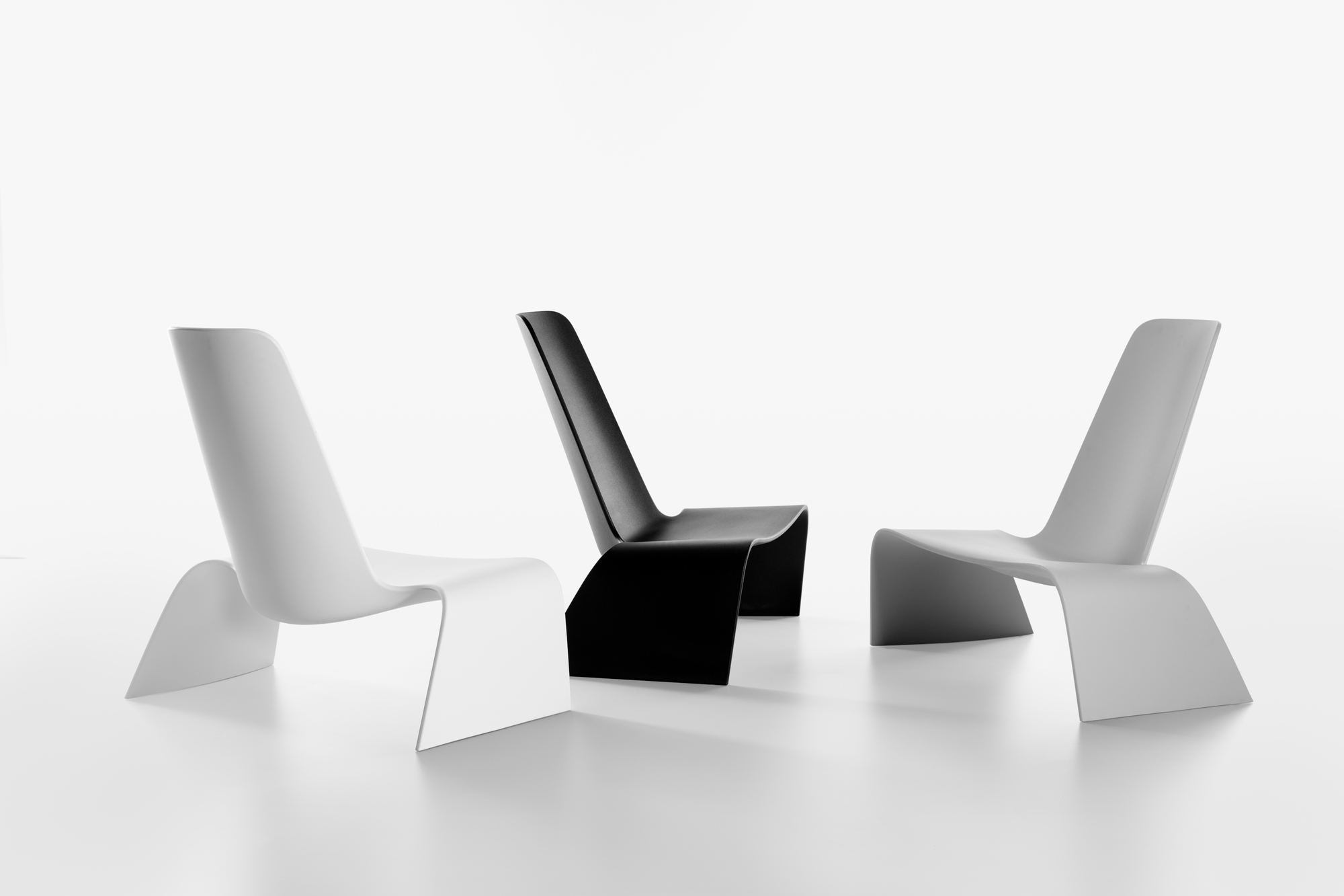 Drei moderne Sessel, darunter ein Land Lounge Chair in Schwarz, Weiß und Grau.