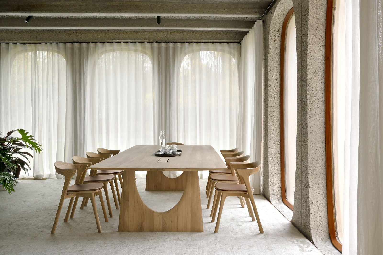 Ethnicraft Geometric Meetingtisch aus Eiche mit Kabelboxen in einem hellen, modernen Konferenzraum mit Stühlen.