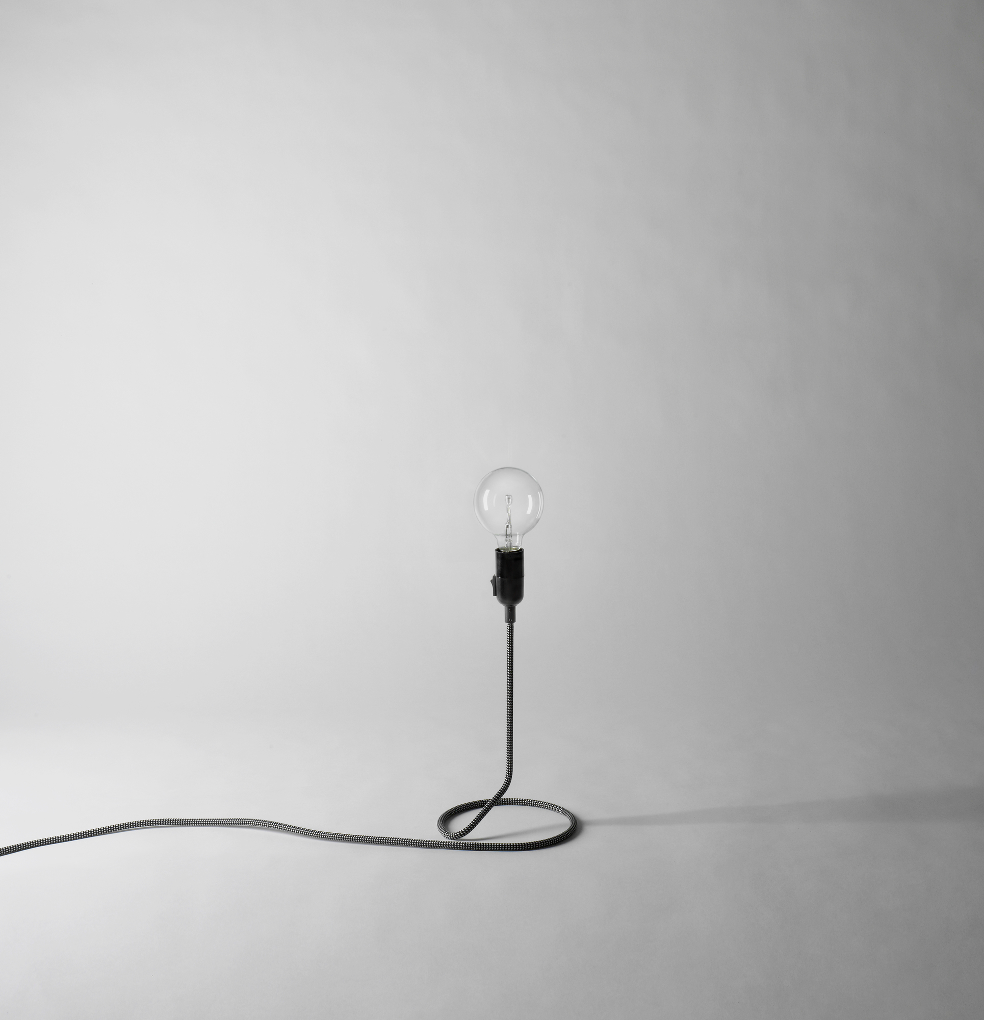 Cord Lamp Leuchte von Design House Stockholm: Minimalistische Tischleuchte mit dekorativem Textilkabel und Glühbirne.
