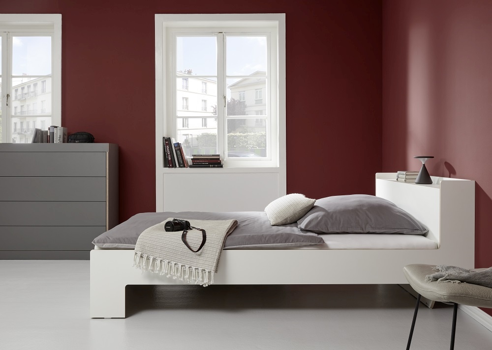 Nook Einzelbett von Müller Möbelwerkstätten in Weiß mit Nachttisch und anthrazitfarbener Kommode.