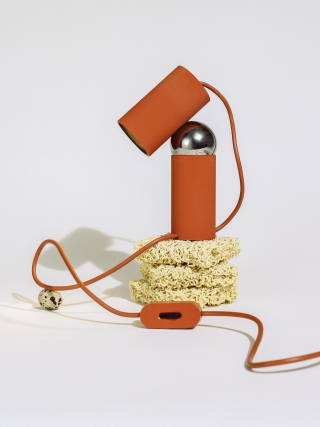 Bilboquet Tischleuchte in Salbei: Moderne Designerlampe mit orangefarbenen Zylindern und silberner Kugel auf hellem Hintergrund.