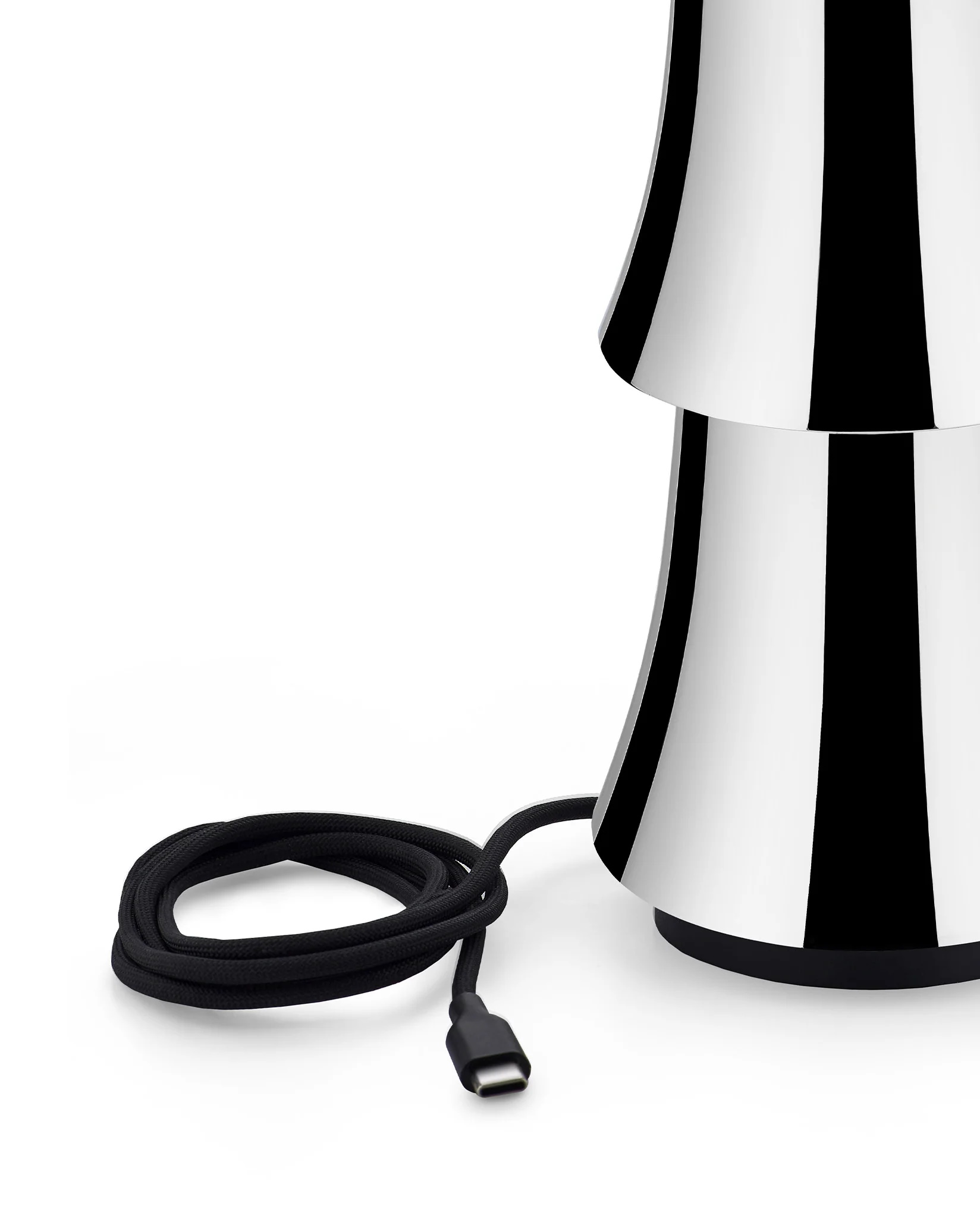 Detailaufnahme der Alessi Halesia Tischleuchte mit schwarz-weißem Muster und USB-C-Ladekabel auf weißem Hintergrund.