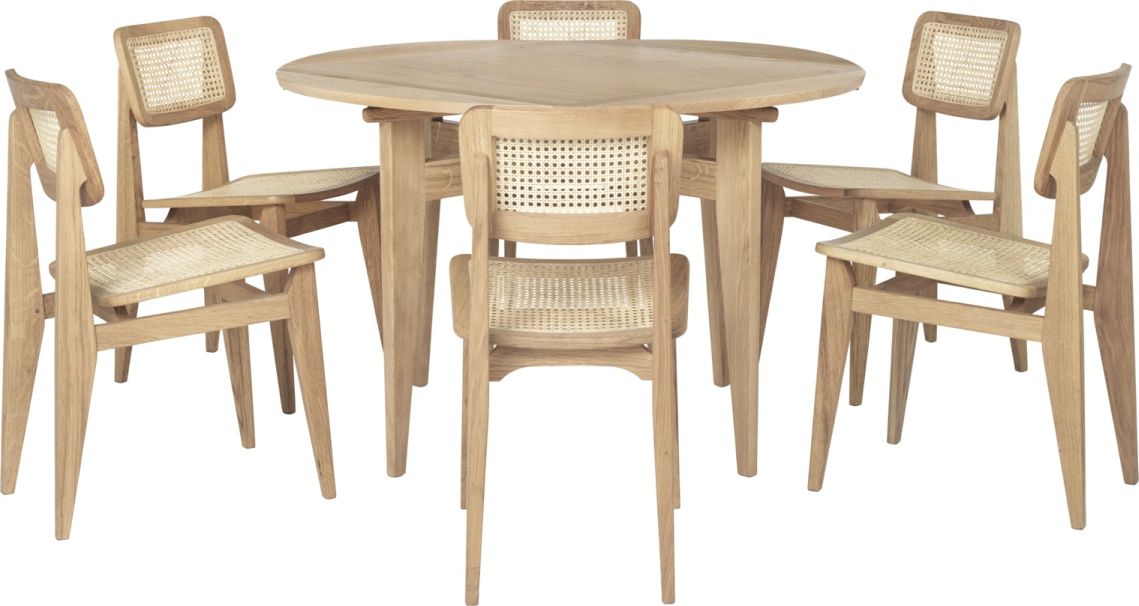 Gubi B-Table Esstisch ausziehbar mit sechs Holzstühlen mit Rattanlehne und -sitz vor weißem Hintergrund.