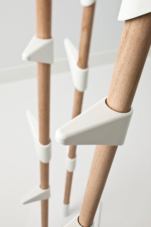 Detailaufnahme der Cascando Bamboo Wandgarderobe: Helle Holzstäbe mit weißen, dreieckigen Haken für Jacken und Accessoires.
