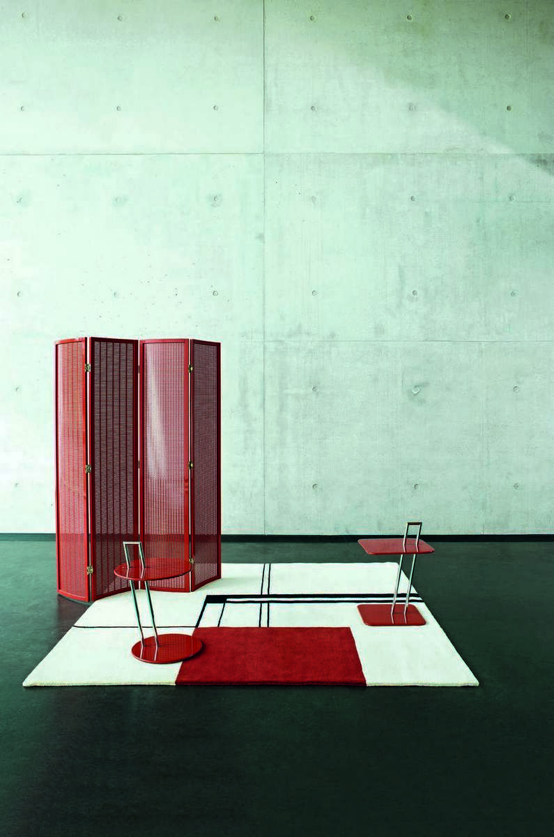 ClassiCon Beistelltisch Occasional Table in Rot mit Raumteiler und Teppich auf dunklem Boden.