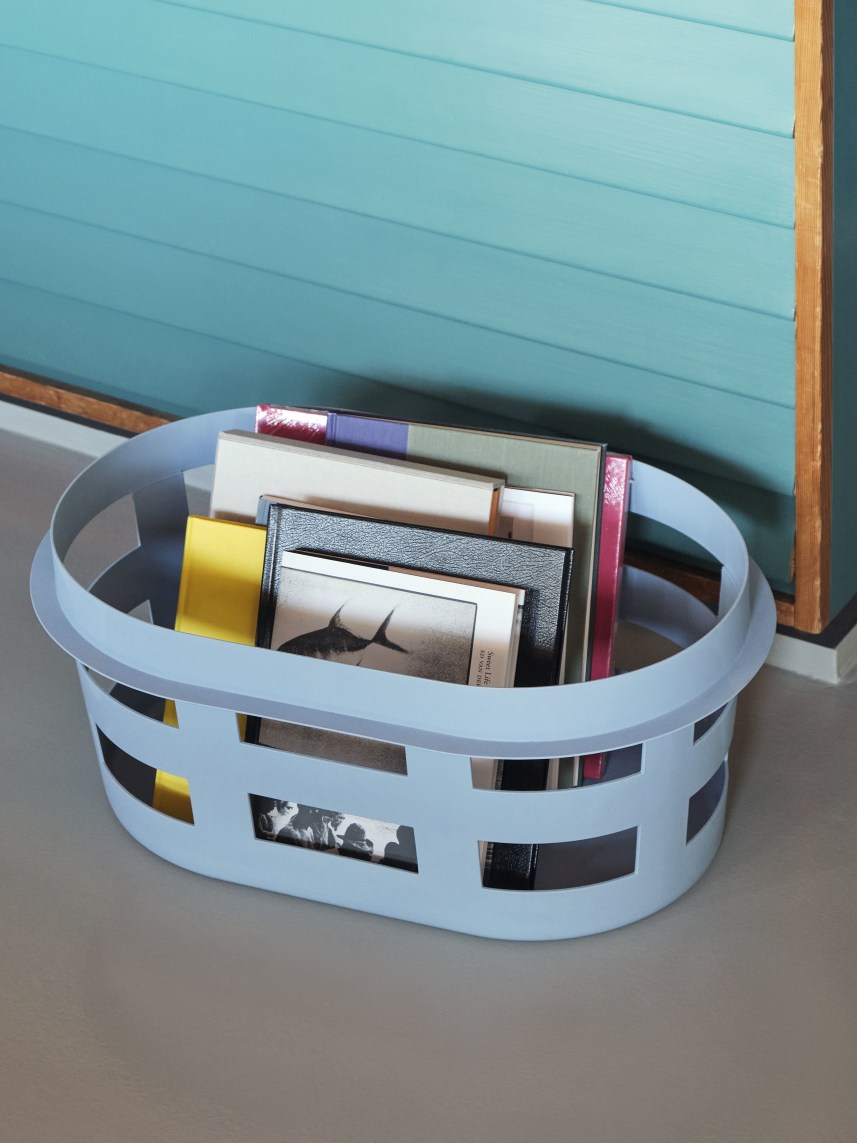 Heller, blauer Hay Wäschekorb S RECYCLED gefüllt mit Büchern und Zeitschriften. Moderner Wäschebehälter für Bad oder Schlafzimmer.