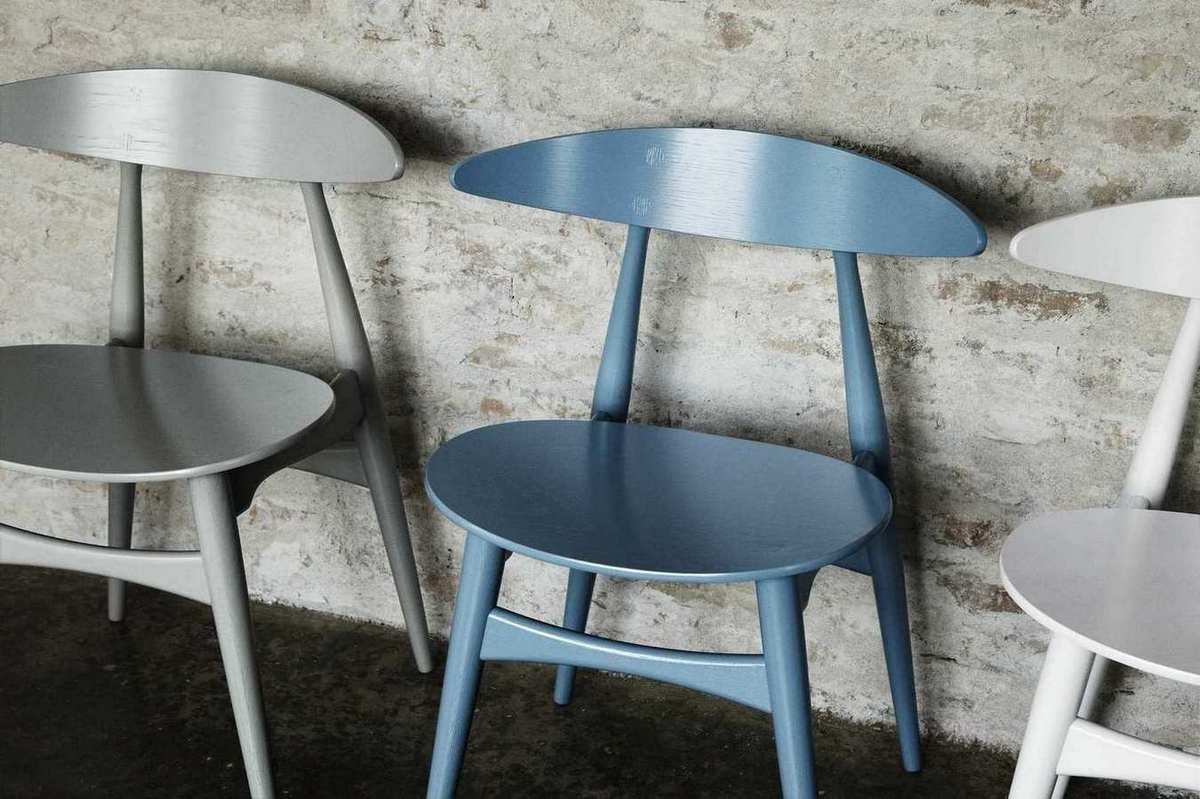 CH33 Stühle von Carl Hansen & Søn in Grau, Blau und Weiß vor einer Ziegelwand.