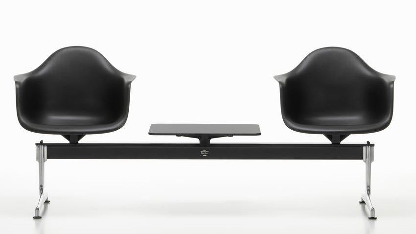 Schwarzer Eames Plastic Armchair auf Traverse von Vitra mit Tischplatte, modernes Design für Wartebereiche.