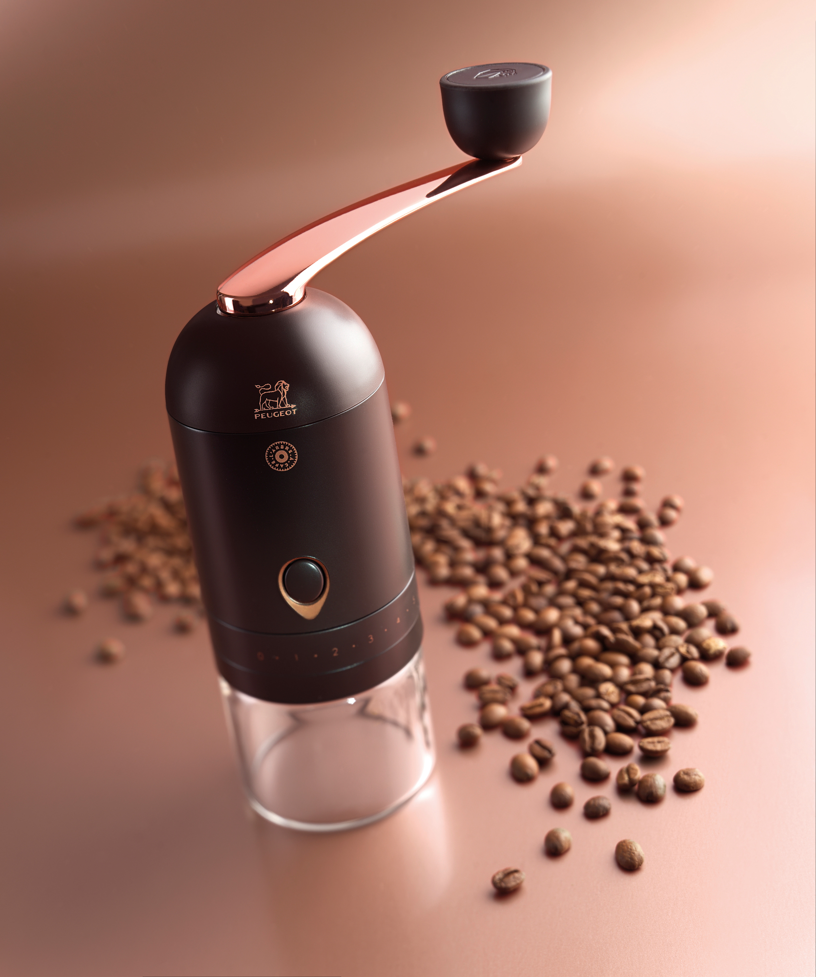 L'Arbre à Café Peugeot Kaffeemühle mit Handkurbel und Kaffeebohnen auf braunem Untergrund.