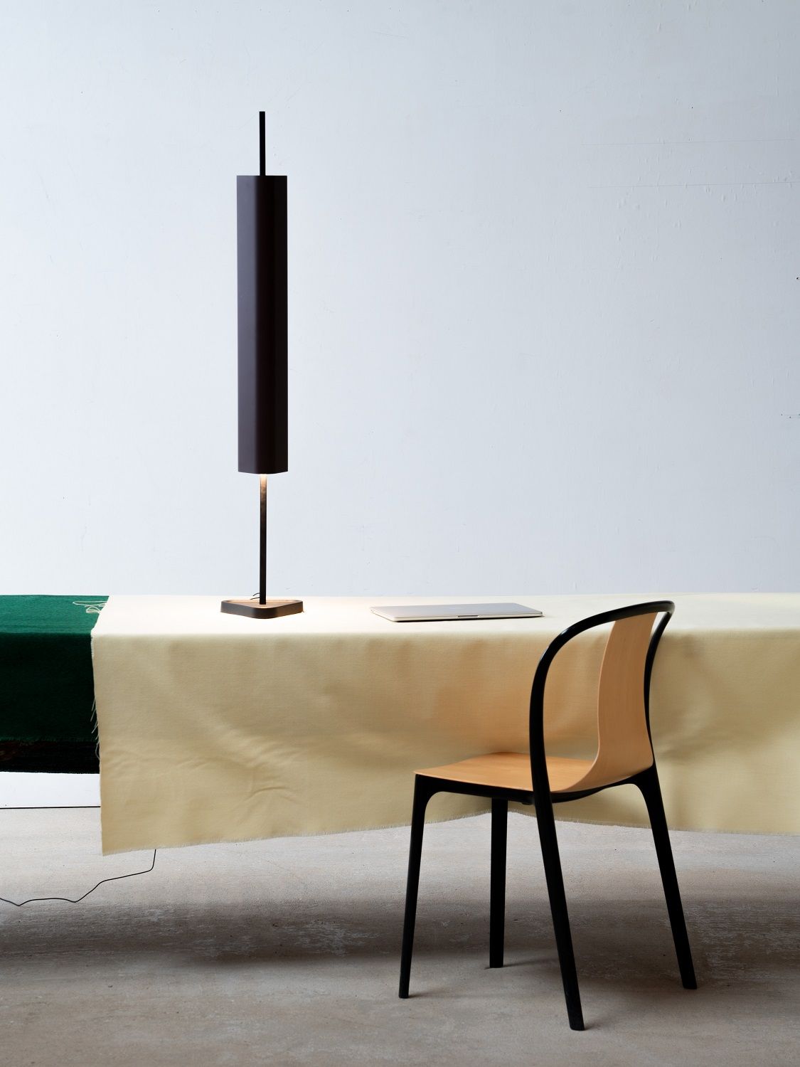 Emi Table Tischleuchte von Flos, moderne Schreibtischlampe in Schwarz auf einem Tisch mit Stuhl.