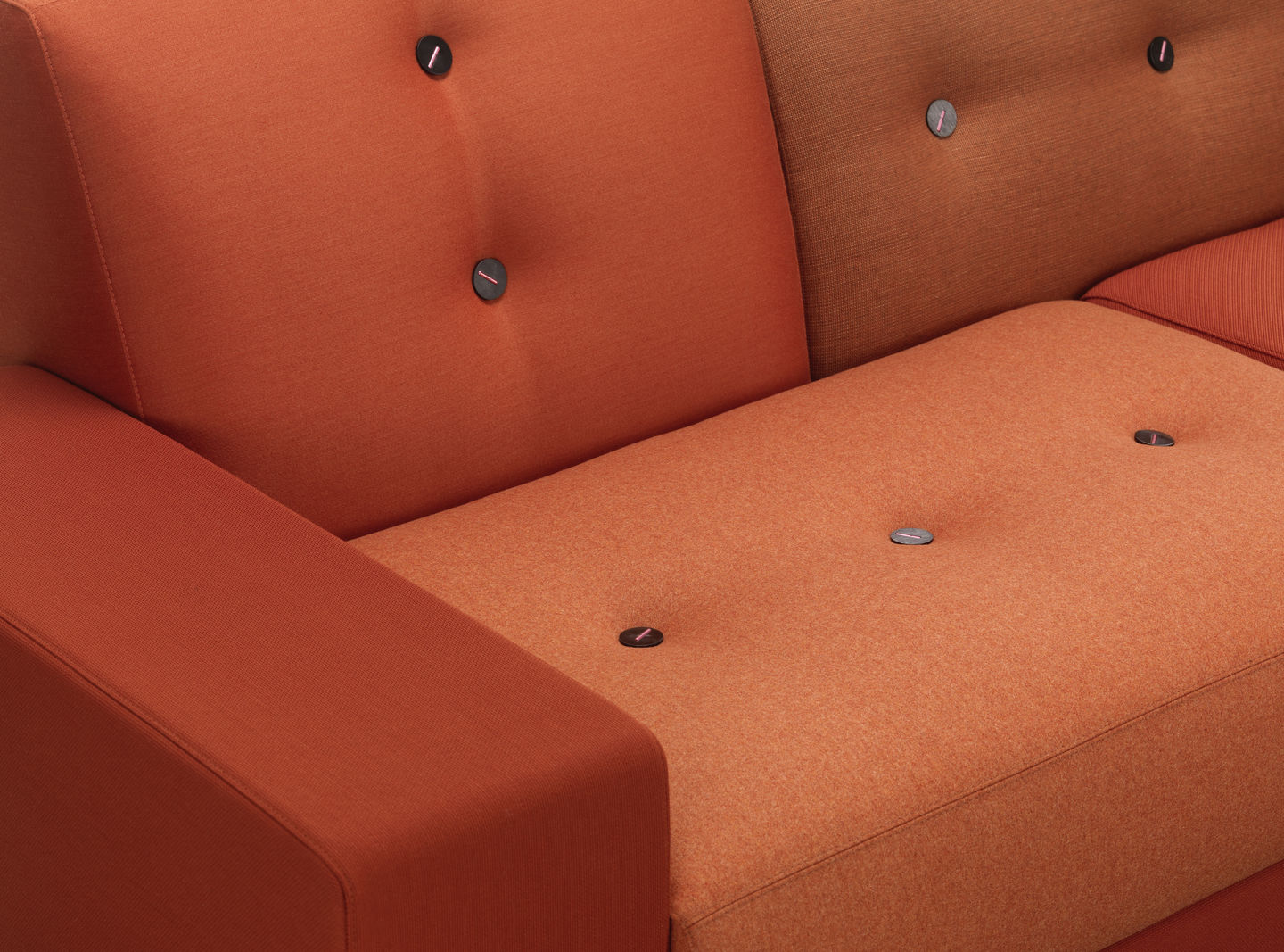 Detailaufnahme des orangefarbenen Vitra Polder Sofas mit Knopfdetails, ideal für modernes Wohnzimmerdesign.