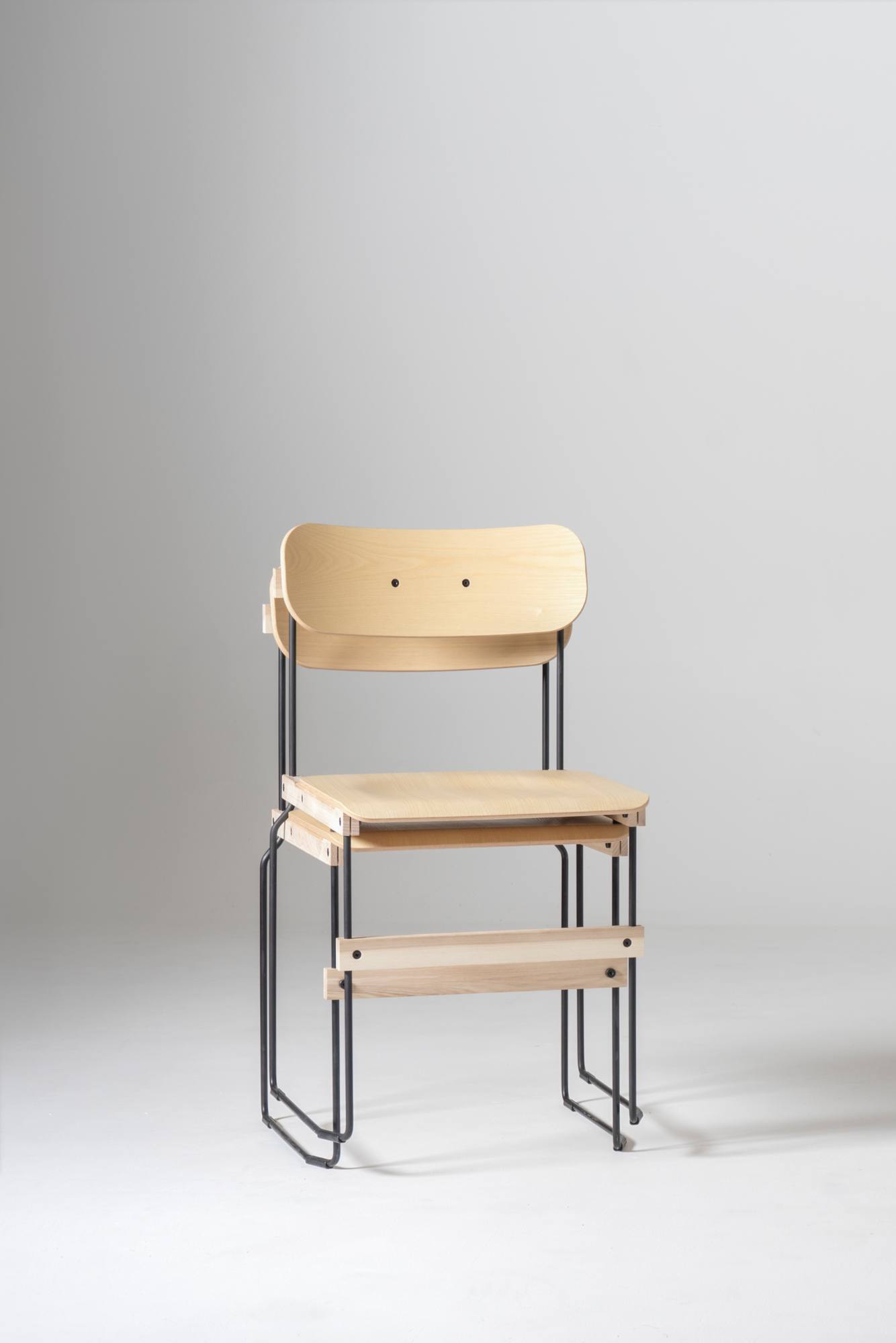 Bruto Stuhl von Nils Holger Moormann: Holzstuhl mit minimalistischem Design und schwarzem Metallgestell.
