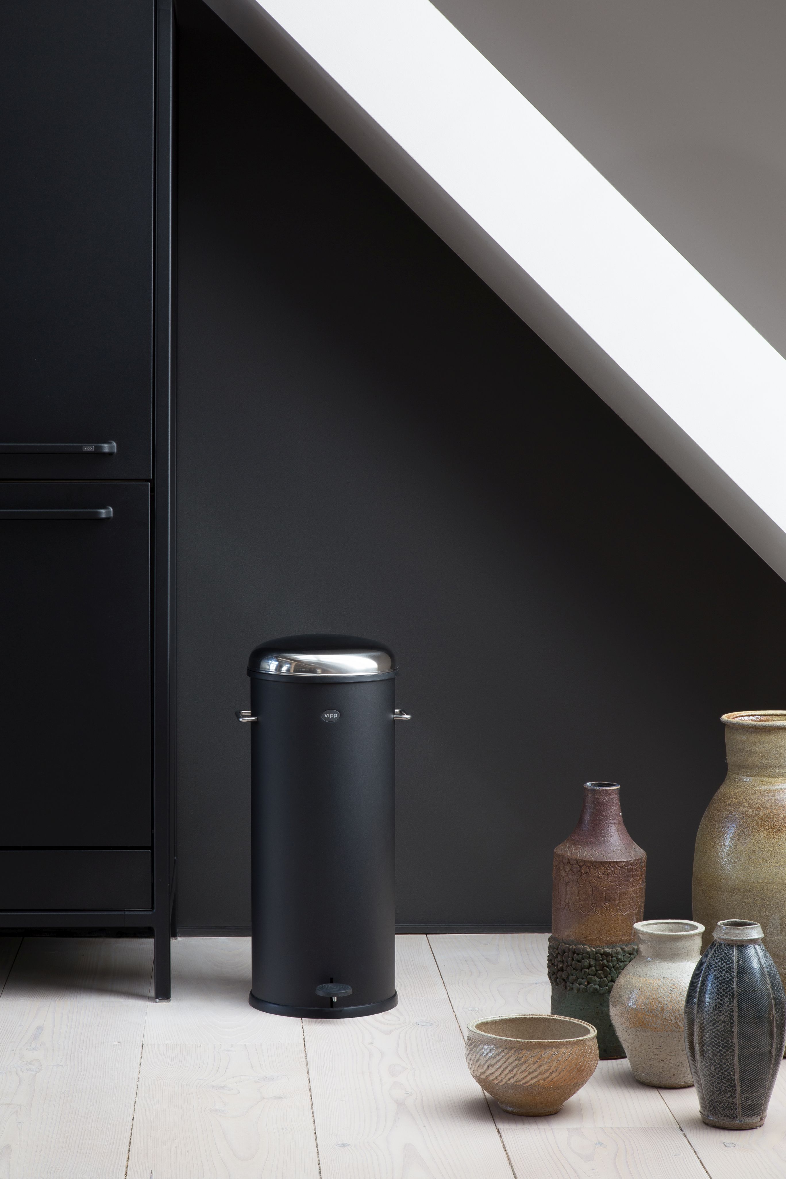 Schwarzer Vipp Treteimer 30L im modernen Badezimmer mit dunkler Wand und hellen Holzboden.