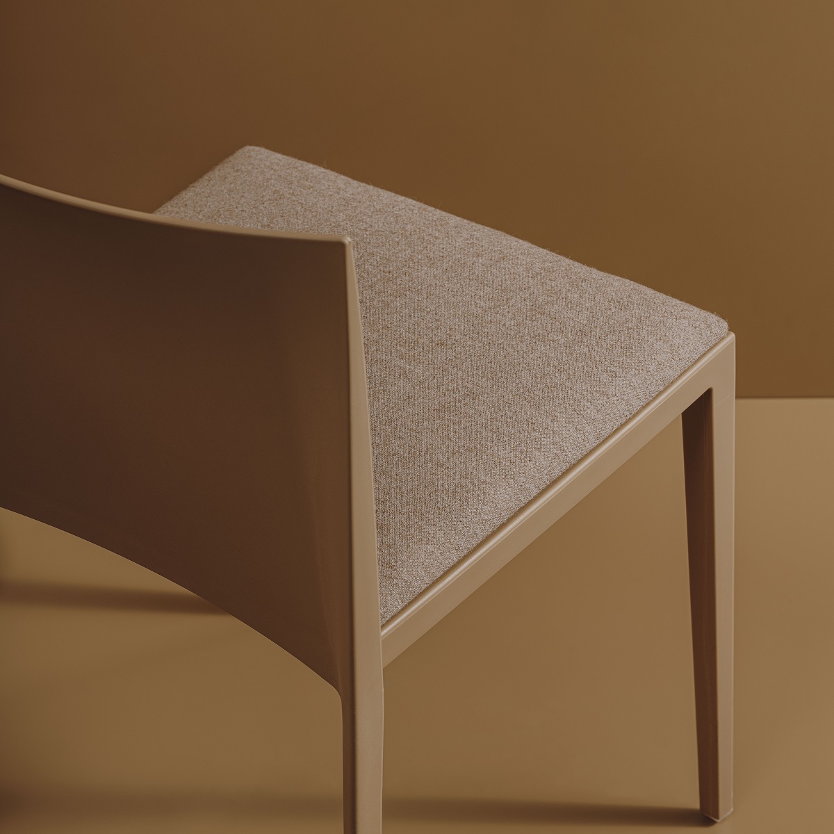 Detailaufnahme des Sail SI1245 Stuhls von Andreu World, stapelbarer Designstuhl mit beigem Stoffbezug und Rahmen.