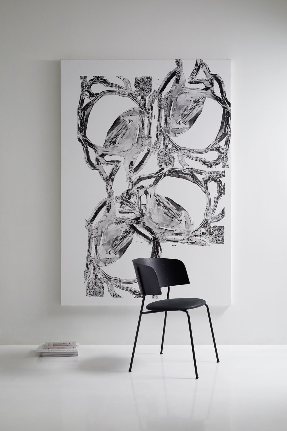 WAGNER Armlehnstuhl OUT mit schwarzem Gestell vor einem abstrakten Kunstwerk, moderne Sitzmöbel für Wohnraum.