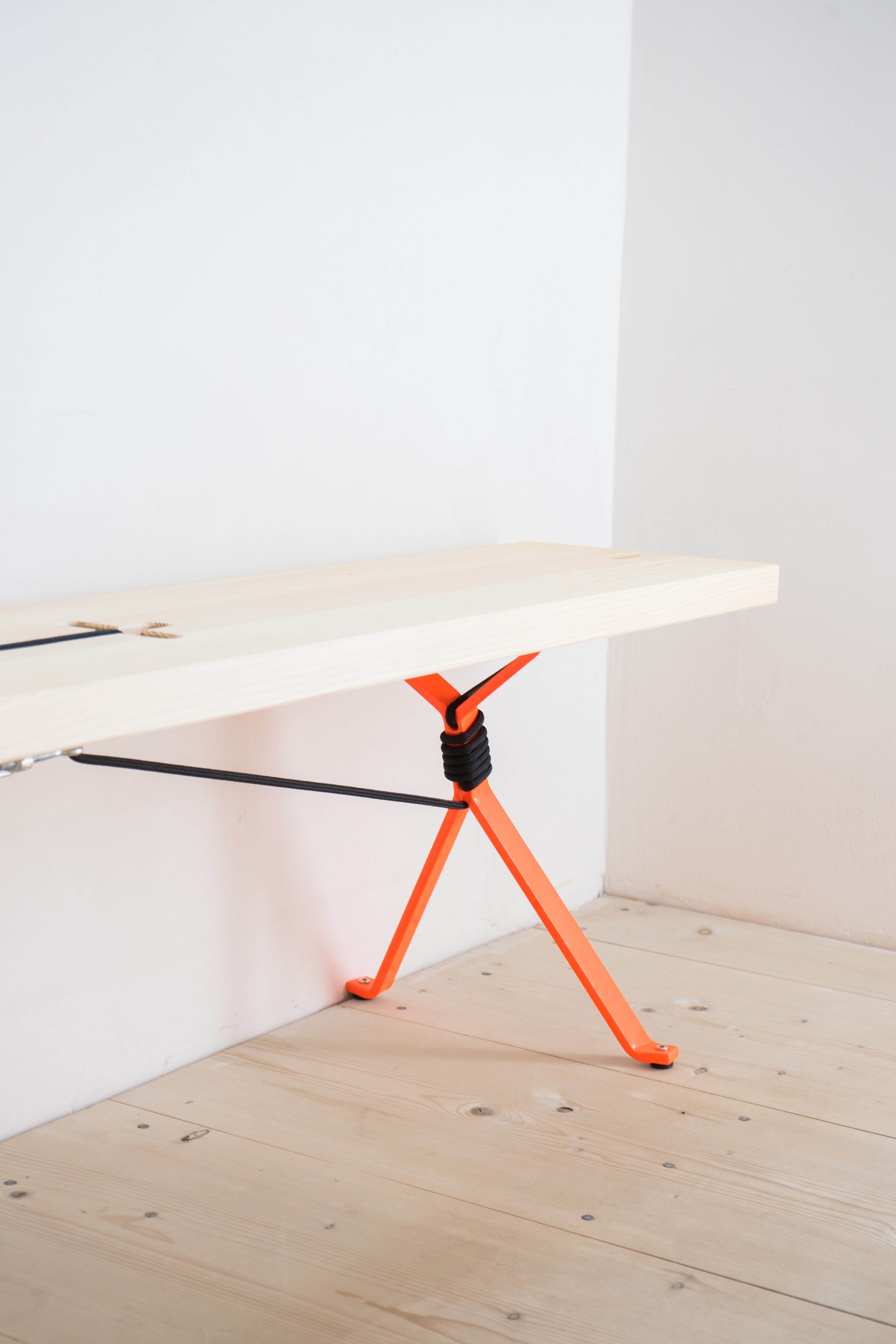 Nils Holger Moormann Kampenwand Bank aus hellem Holz mit auffälligem, orangefarbenem Gestell.