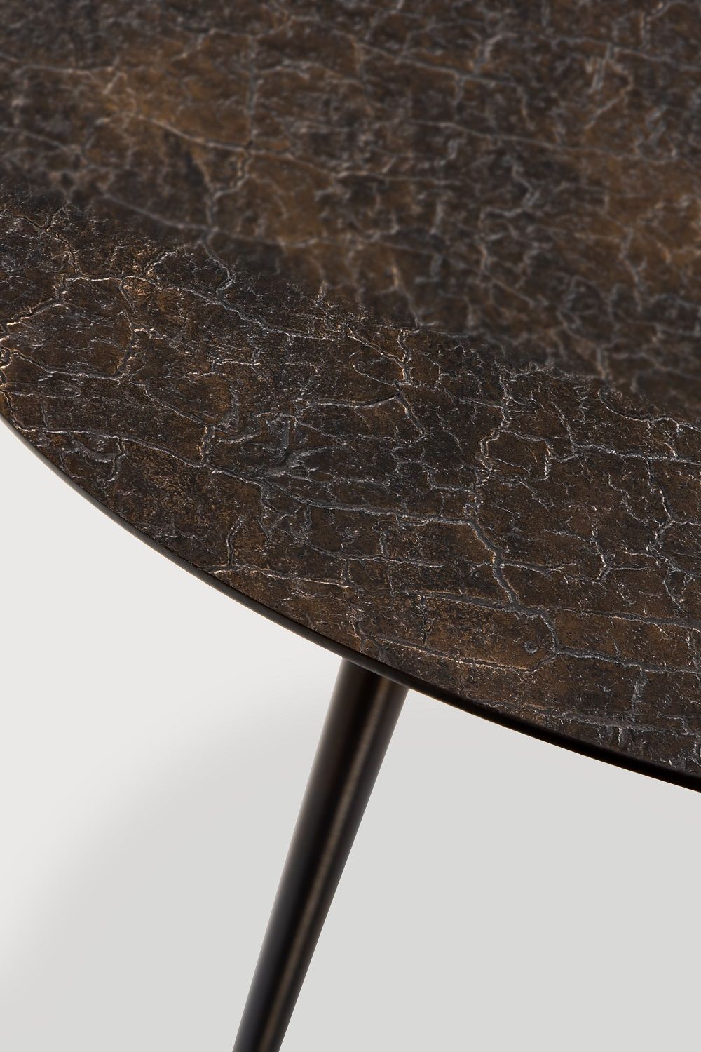 Detailaufnahme des Luna Couchtisches von Ethnicraft mit dunkler, strukturierter Tischplatte und schwarzen Beinen.
