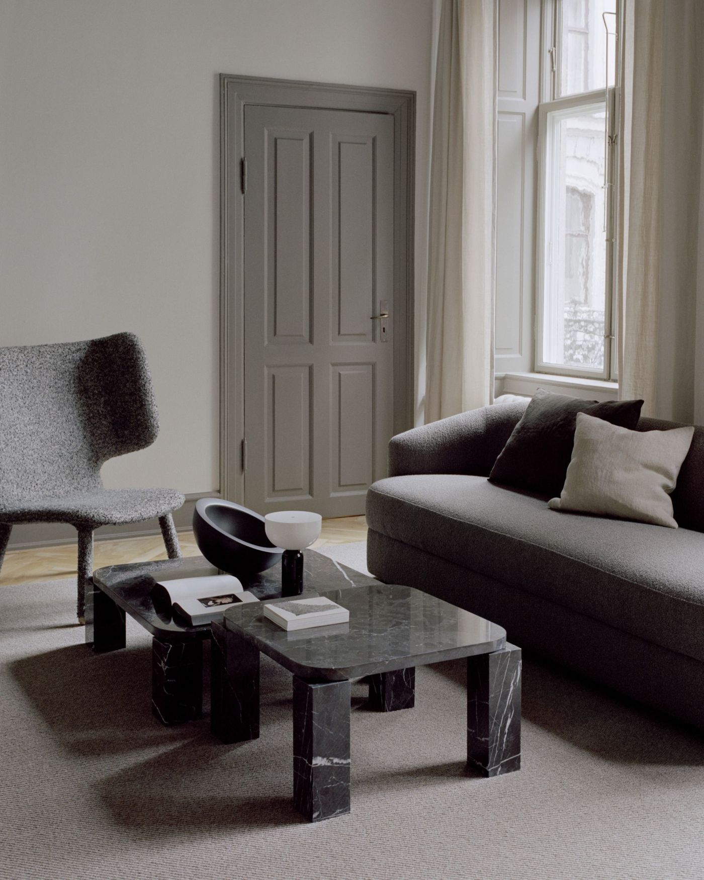 Wohnzimmer mit grauem Sofa, Sessel und Marmor Couchtisch Set, moderne Inneneinrichtung.