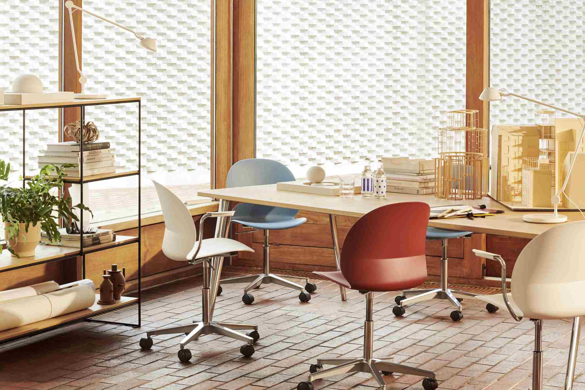 Büro mit Holztisch und Fritz Hansen N02 Recycle Stühlen in Weiß, Blau und Rot.
