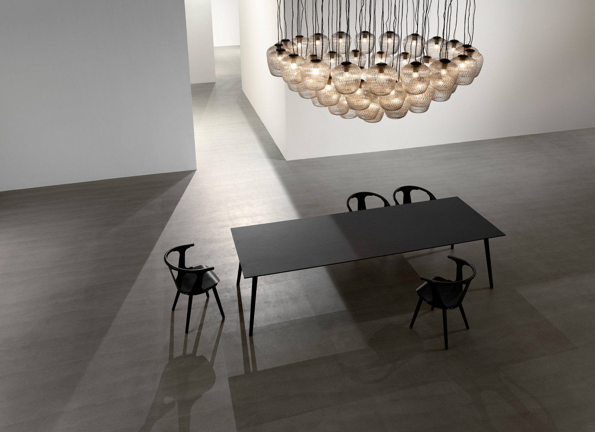 AndTradition In Between Chair SK1, schwarz lackiert, aus Eiche, mit Esstisch und dekorativer Lampe.