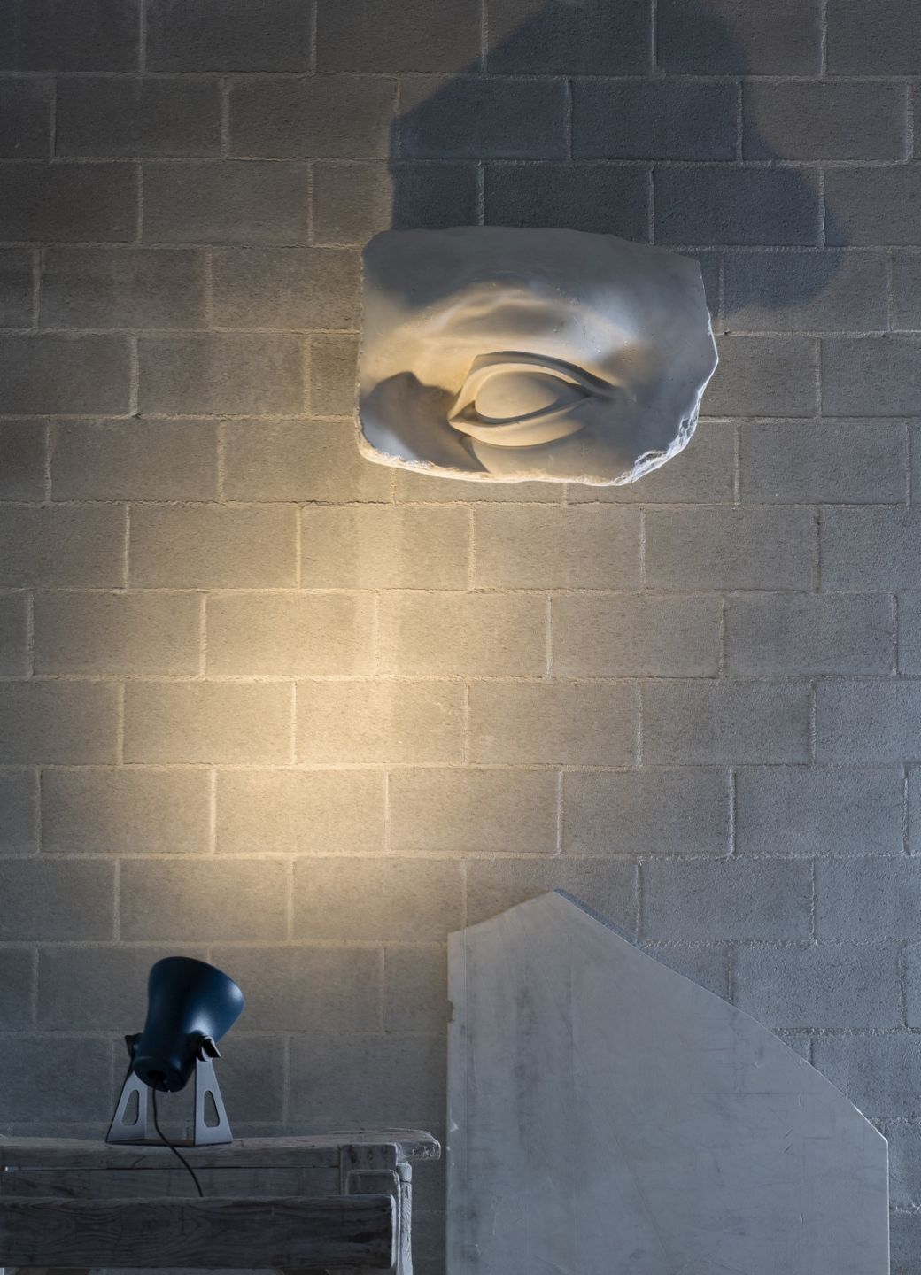 Nahaufnahme der Martinelli Luce Mini Frog Außenleuchte, die eine Wand mit einem Gipsabdruck beleuchtet.