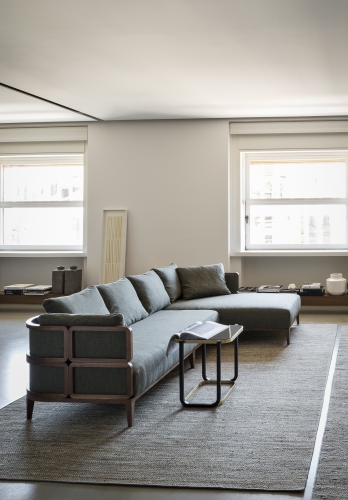 Duet A Beistelltisch von Wiener GTV Design neben einem grauen Ecksofa auf einem Teppich.