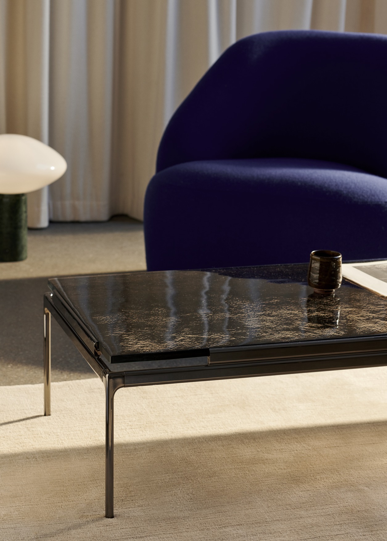 AndTradition Sett Couchtisch LN12/LN13 mit dunkler Tischplatte und schwarzem Metallgestell, modernes Wohnzimmerdesign.