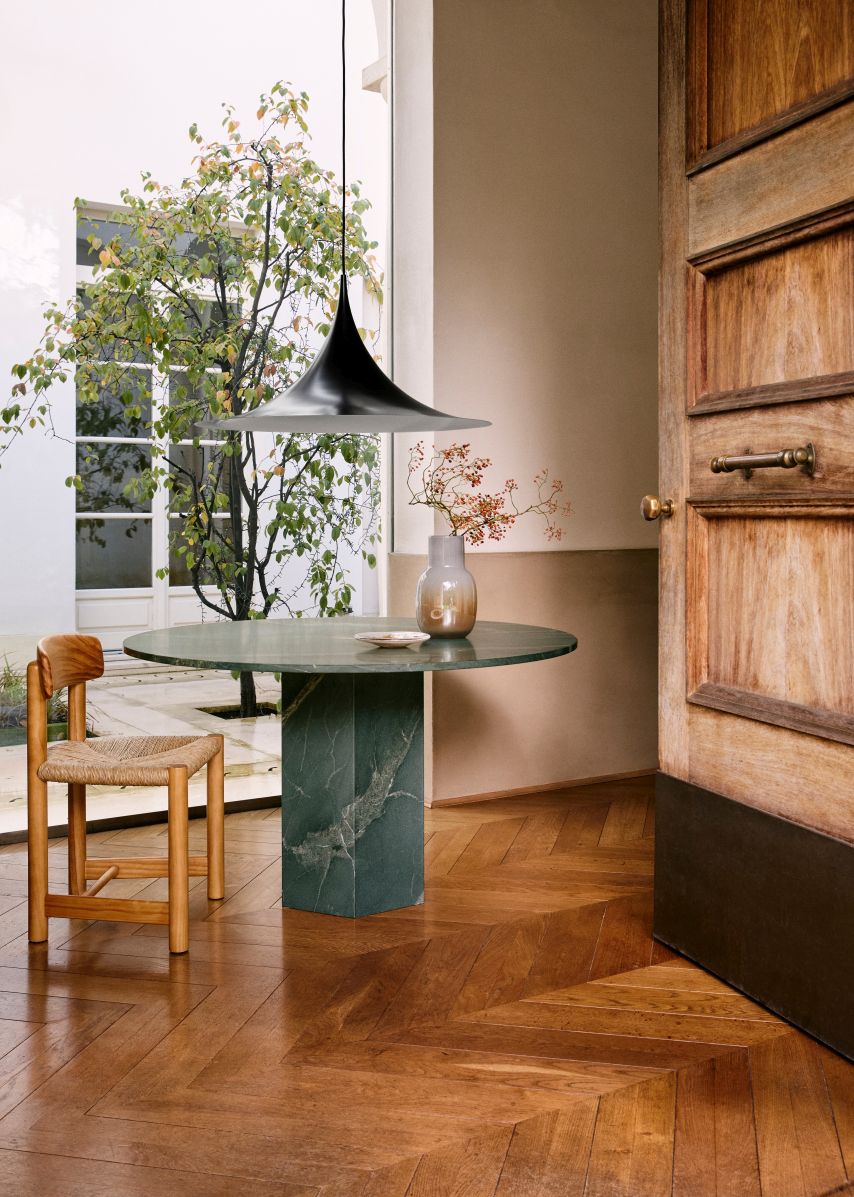 Epic Outdoor Esstisch von Gubi, runder Marmortisch mit Stuhl und Pendelleuchte in stilvollem Interieur.
