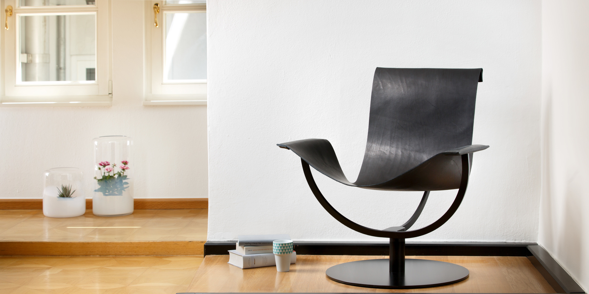 Arch Chair Favius Sessel: Moderner Ledersessel in Schwarz mit minimalistischem Design und Drehfuß.