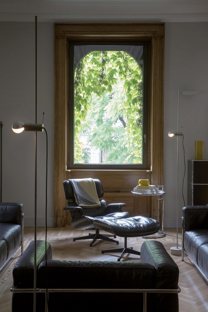 Agnoli Stehleuchte von Oluce in modernem Wohnzimmer mit Ledersofa und Sessel.