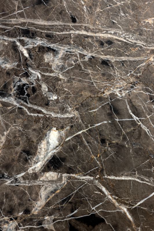 Detailaufnahme der Marmorplatte des Kuyu Marble Couchtischs mit einzigartigen, weißen Maserungen auf dunklem Grund.